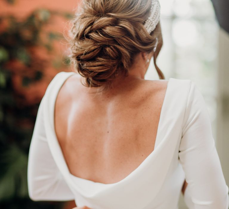 Bride with elegant wedding updo and cowl back Elbeth Gillis gown with button details 