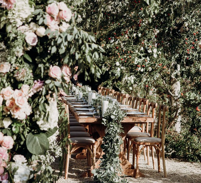 Pink and white floral installation at Euridge Manor Orangery wedding with roses, dahlias and hydrangeas surrounding rustic wedding table