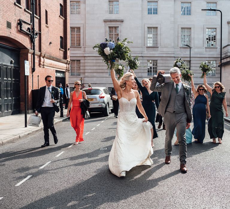 Bride & groom walk and dance with wedding party after wedding ceremony