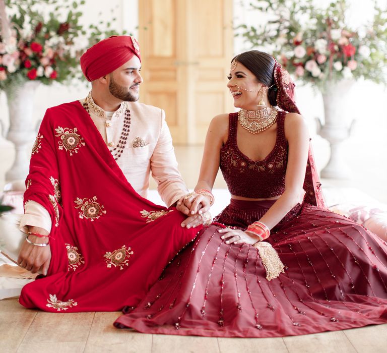 Sikh couple sit together whilst laughing and holding hands