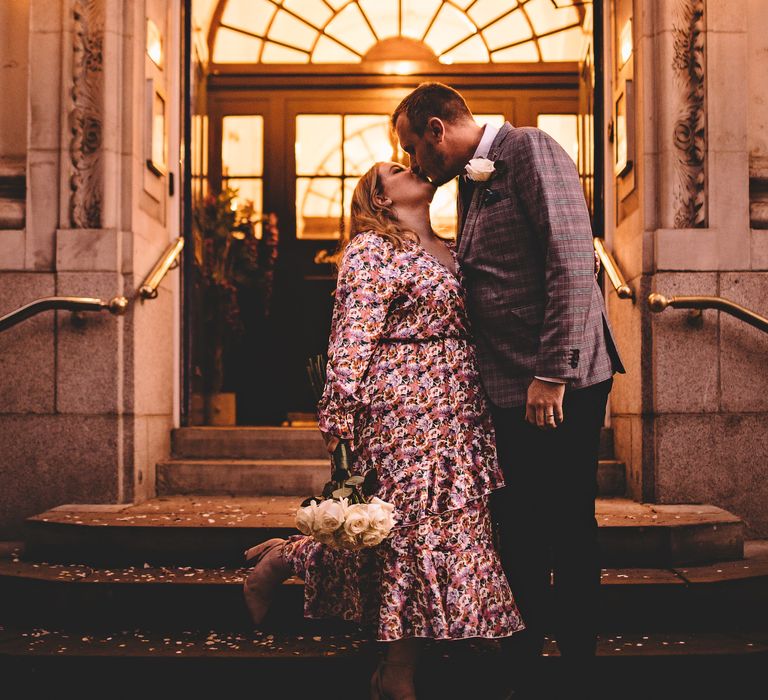 Bride & groom kiss on the steps of Chelsea Old Town Hall on the day of their wedding