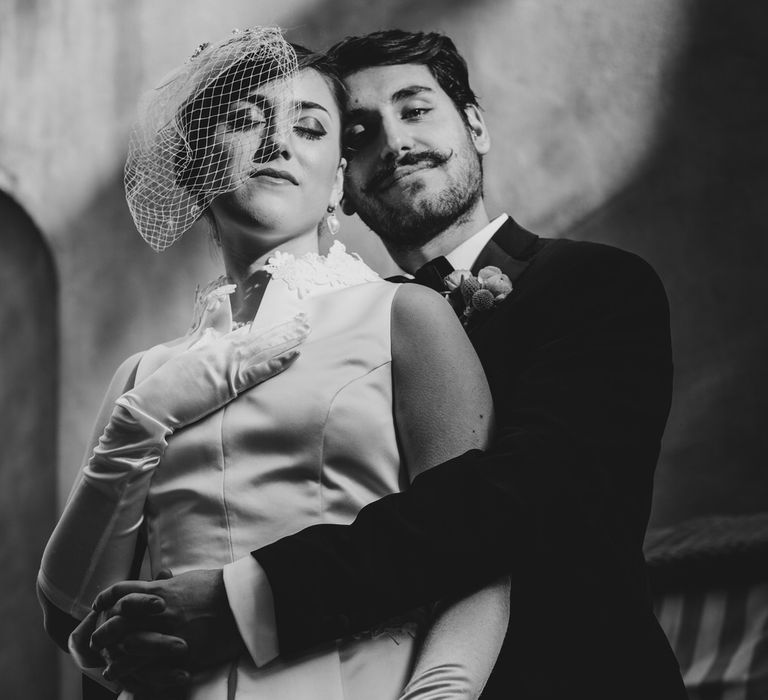 Black and white Hollywood vintage glamour style photo of the bride and groom at their 1960s themed wedding