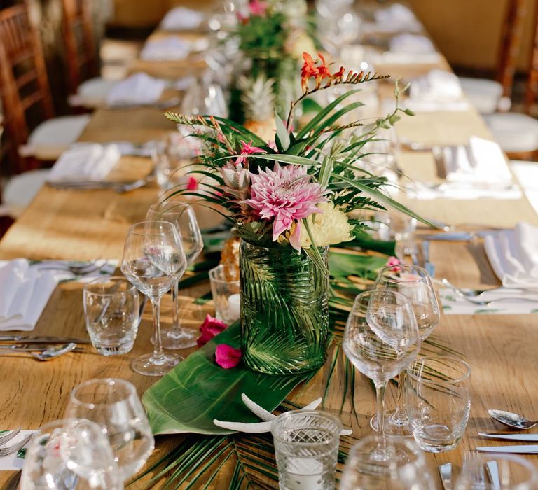 Vibrant flower and tropical leaf wedding table decor