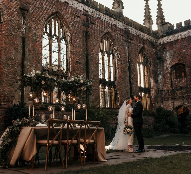 Intimate tablescape with festoon lights and foliage installation at the Bombed Out Church in Liverpool 