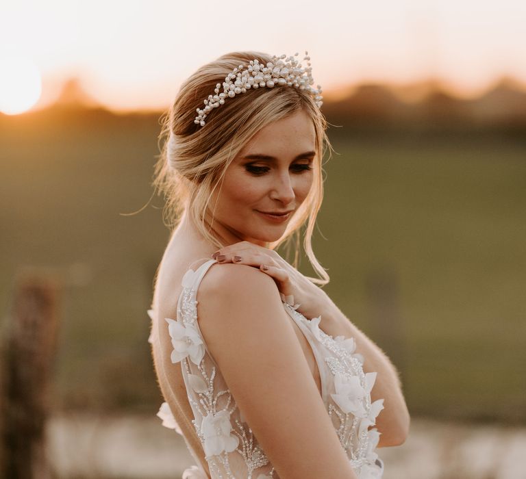 Portrait of a bride during golden house in a pearl headdress with brown eyeshadow and nail polish 