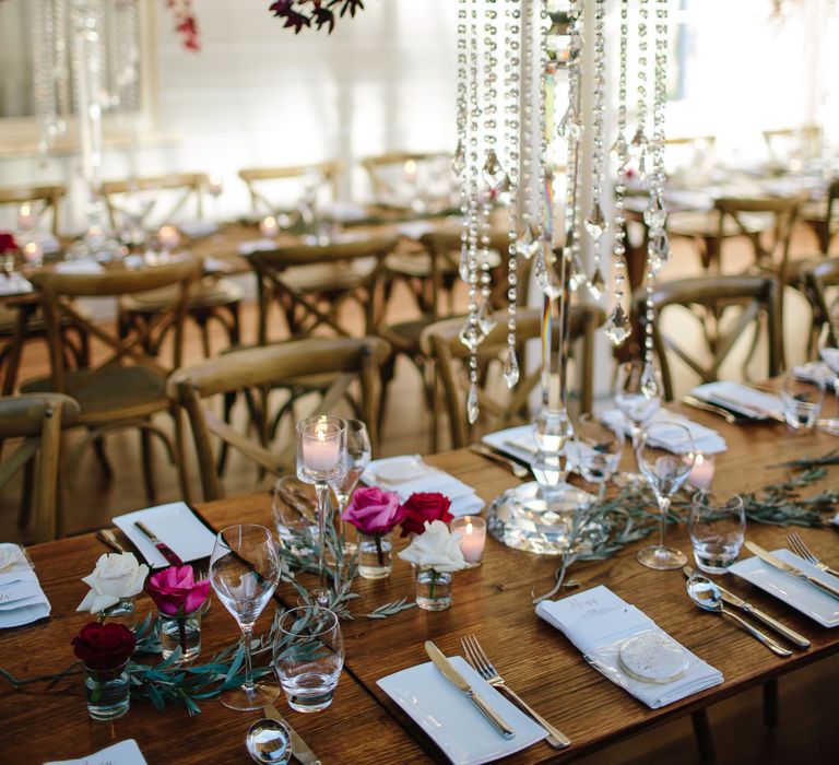 Beautiful and bright floral decor featuring pinks and reds in long stemmed vases for wedding reception