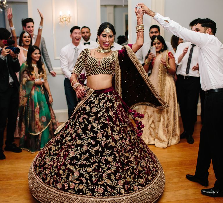 Bride & groom dance on their wedding day as the wedding party looks on 