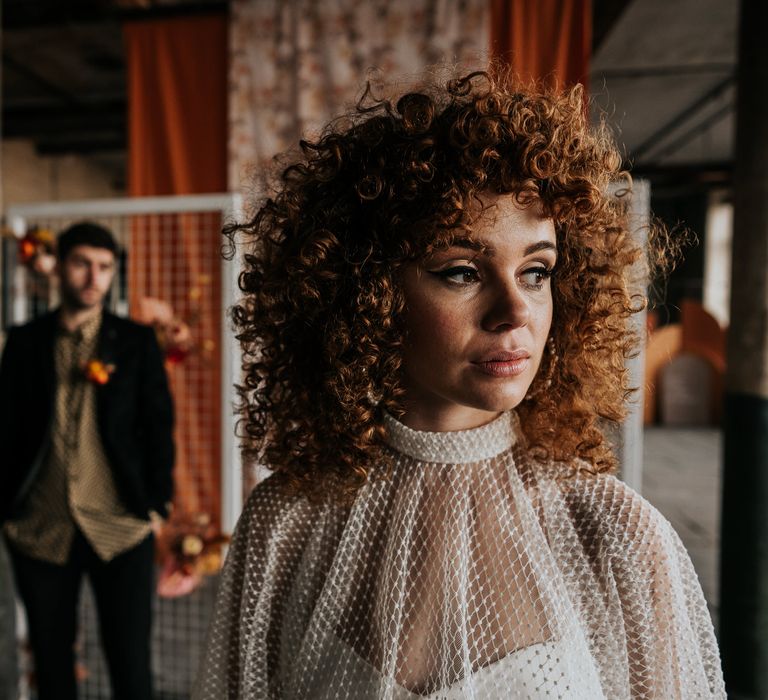 Beautiful bride with freckles with naturally curly hair and winged eyeliner makeup 