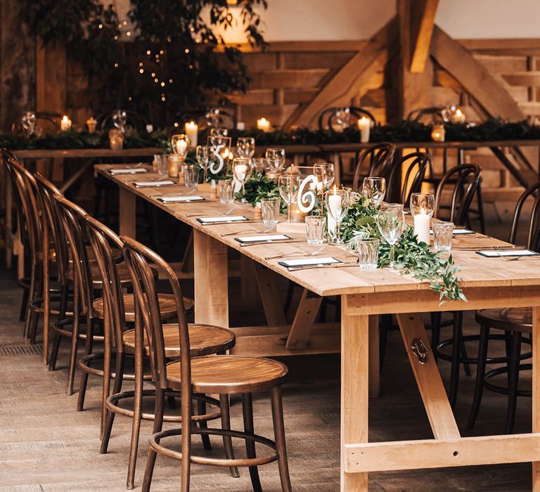 Rustic reception room complete with green foliage along tables 