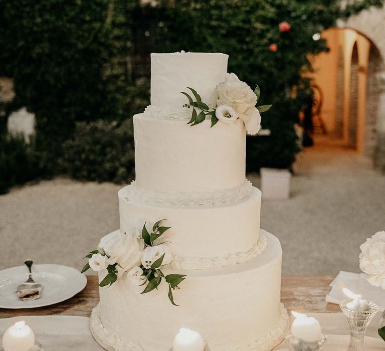 White 4-tier wedding cake complete with floral decor  | Royal Studio