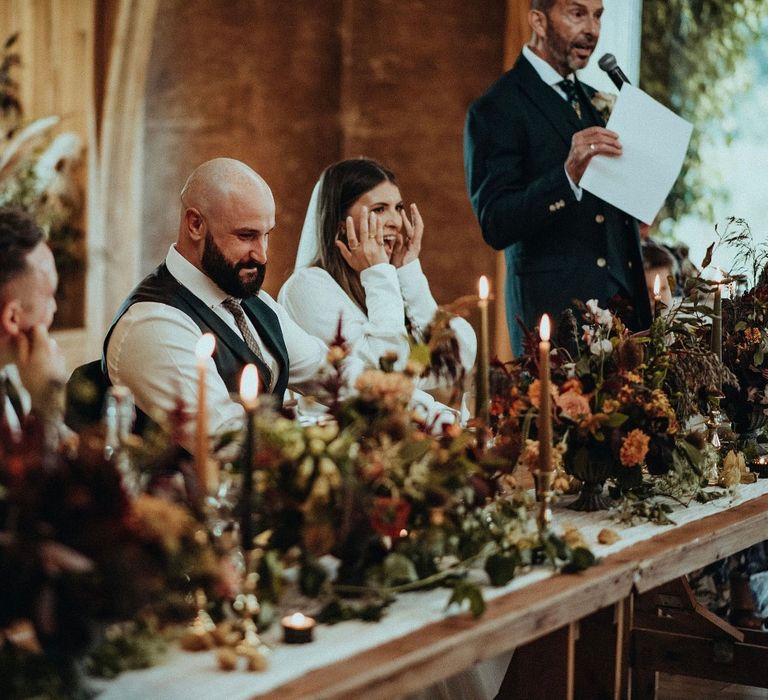 Wedding guest gives speech on the day of wedding as bride laughs 