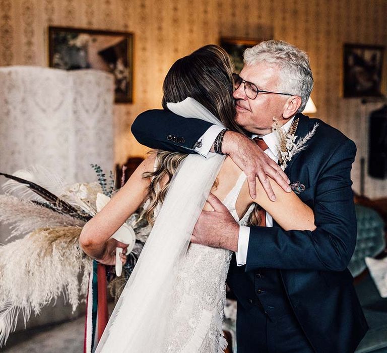 Bride hugs her father on the day of her wedding