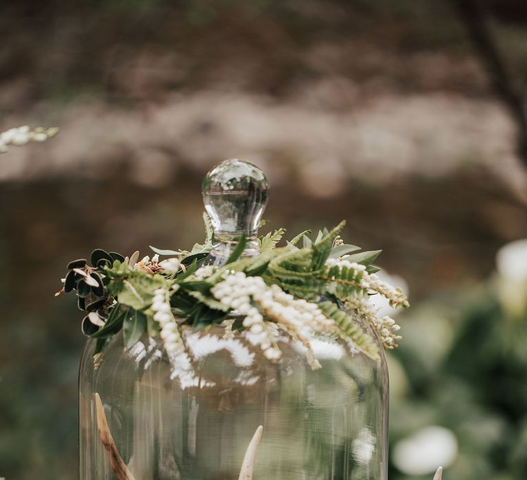 glass cloche wedding decor on a rustic tree slice with moss and antlers 