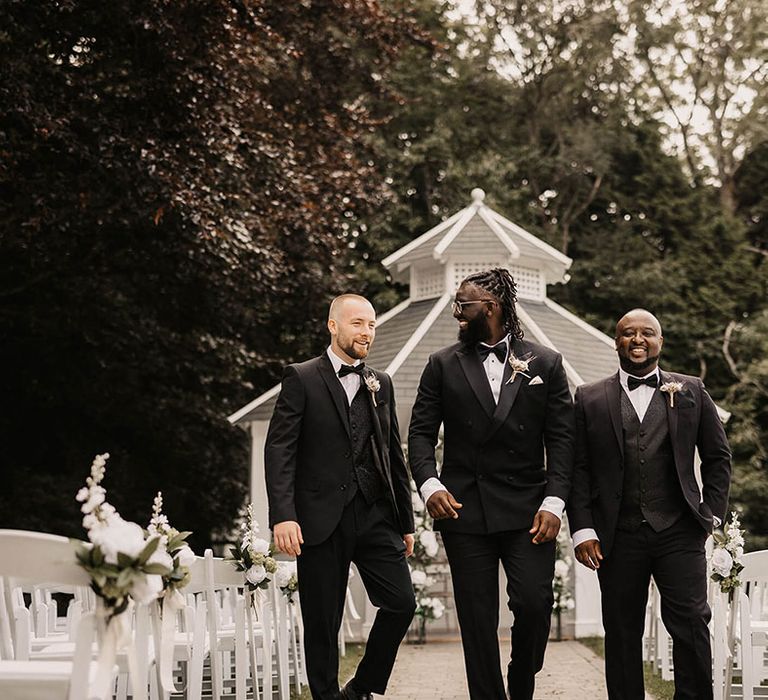 Groom wears black tie with his groomsmen on his wedding day