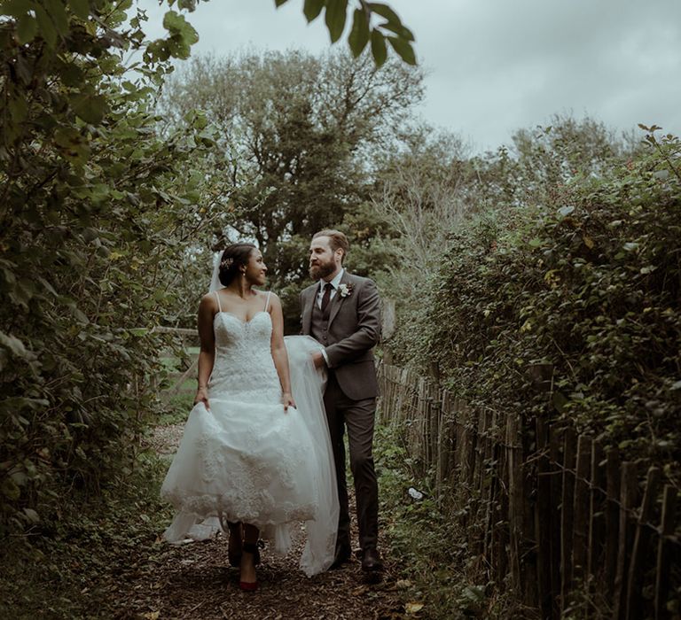 Groom lifts brides bridal gown on her wedding day