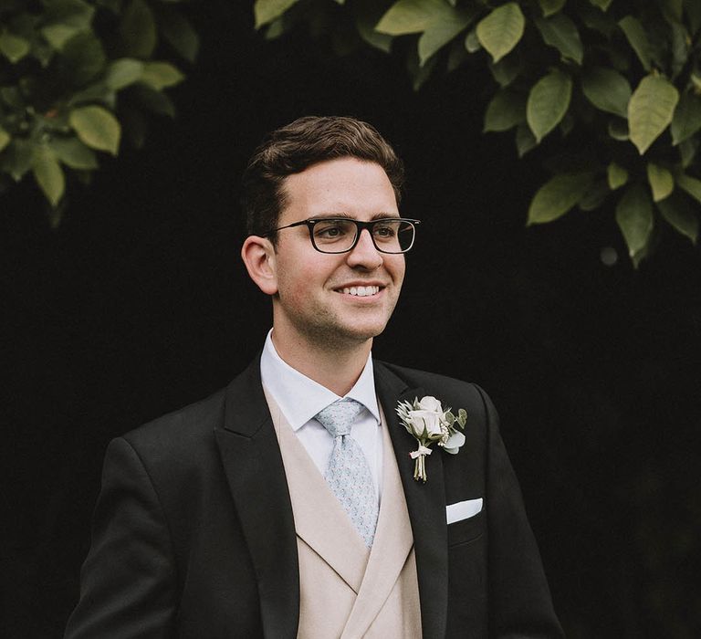 Groom in cream waistcoat and suit with tails