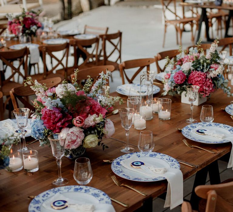 Long wooden banquet tables in Greece complete with bright florals