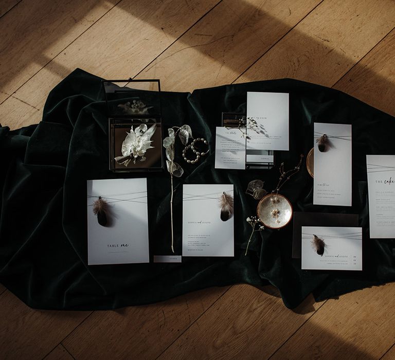 Flatlay of a white stationery suite on a black table cloth 