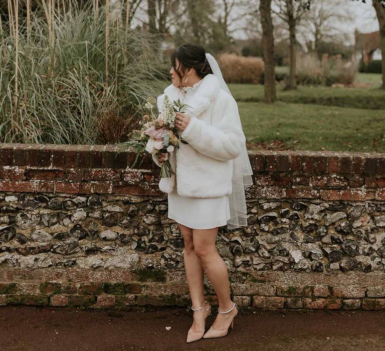 Vanessa Cocchiaro Paris short wedding dress with cropped white fur coat and neutral floral bouquet 