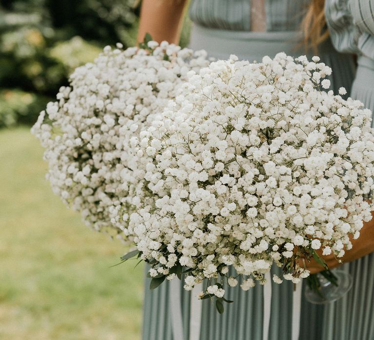 Bridesmaids hold matching gypsophila bouquets 