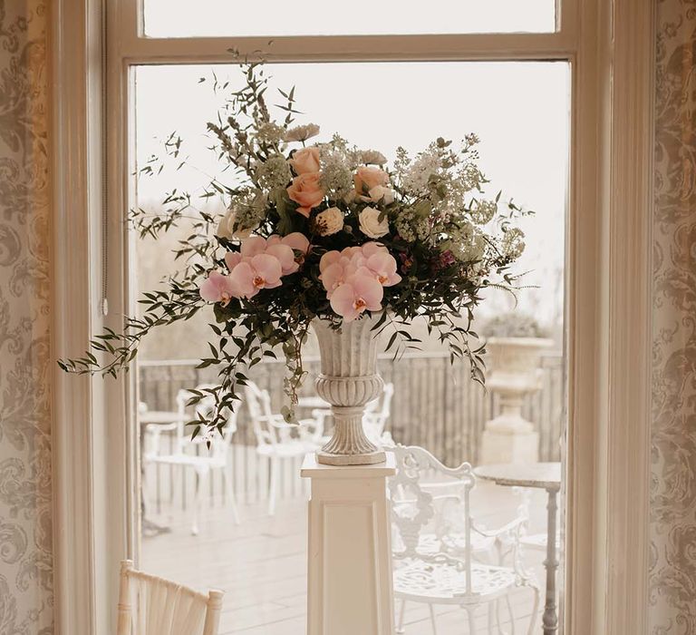 Pink, white, red and green mixed floral display in large white ceramic vase 