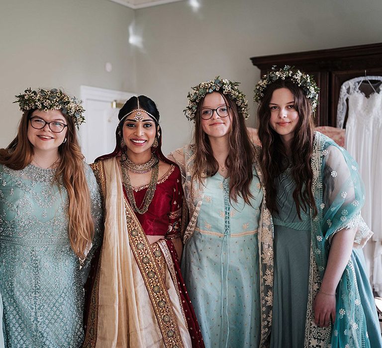 bride smiles with bridesmaids in mint green dresses with matching flower crowns