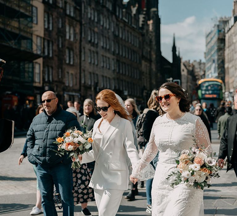 Brides walk the Royal Mile on their wedding day in Edinburgh 