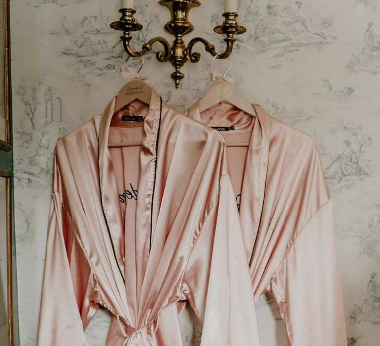 Pink satin bridesmaid robes with pink feathers for bridal party