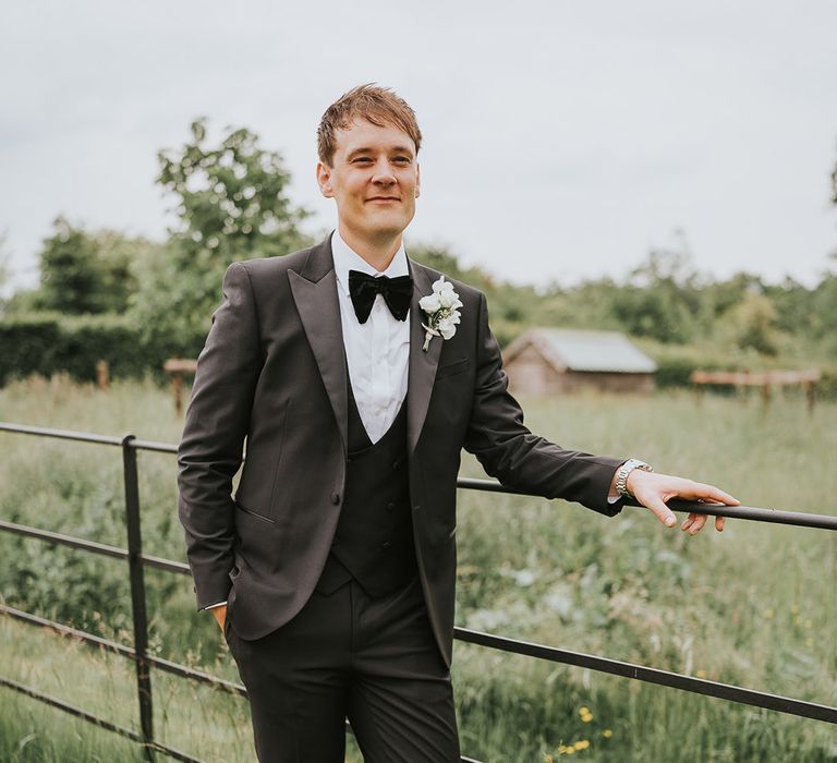 Groom in black tie with white rose buttonhole 