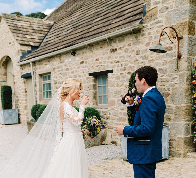 Bride & groom stand outside Tithe Barn on their wedding day after church ceremony 