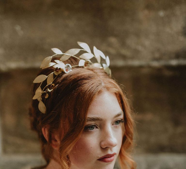 Bride with pinned up do wearing a gold leaf bridal crown headpiece 