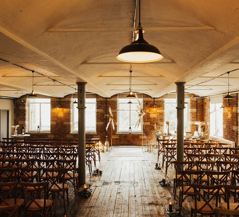 The Venue Bowers Mill wedding venue with rustic vibe and exposed brick wall complete with brass arch with dried floral installations 