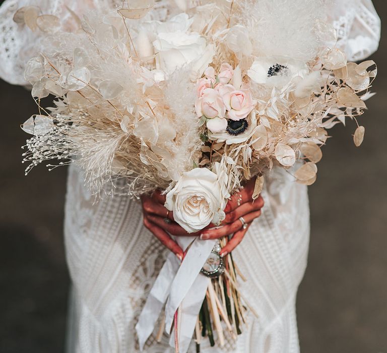 White dried flower wedding bouquet with white poppies, dried grass, and roses 