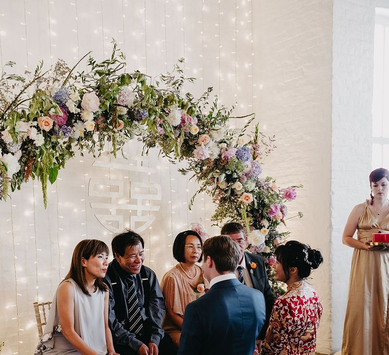 Bride & groom kneel before parents during Chinese Tea Ceremony at Trinity Buoy Wharf