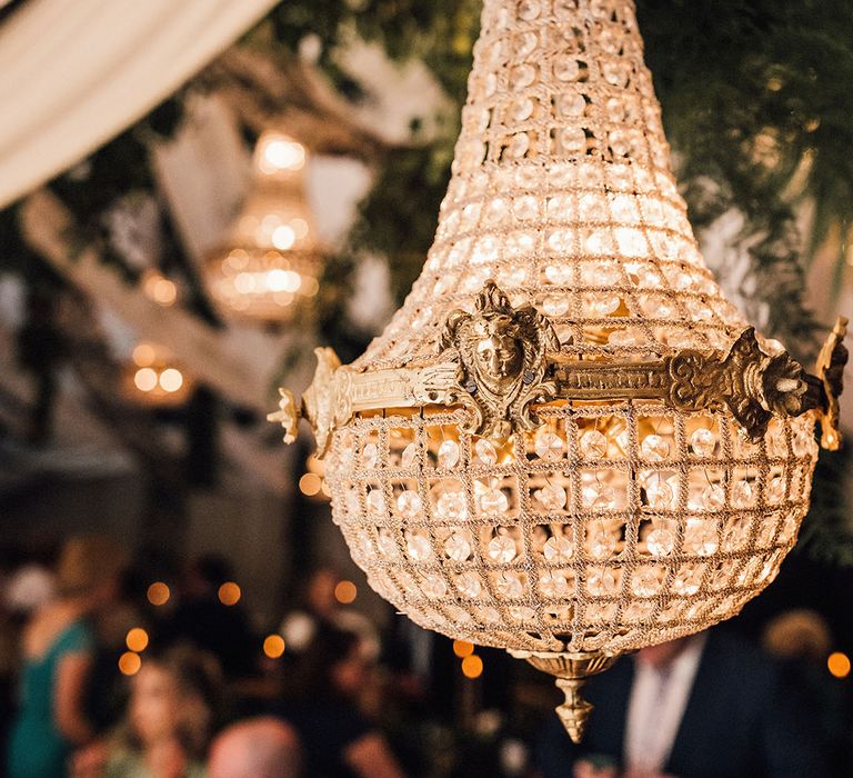 Gold chandelier wedding lighting at the marquee