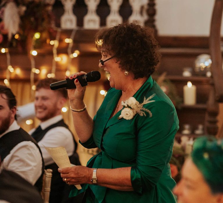 Mother of the bride in a green dress singing during the wedding breakfast 