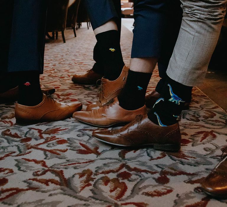 Light brown and dark brown brogue shoes worn by the groomsmen and groom with dinosaur socks 