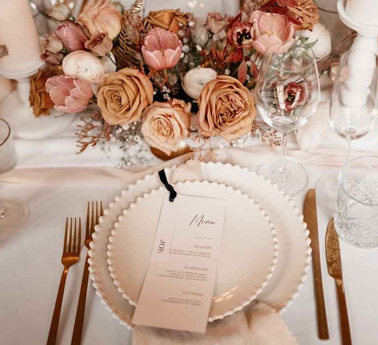 Minimalistic wedding menu on white charger plates with gold cutlery and dried blush garden roses and dried flower wedding centrepieces 