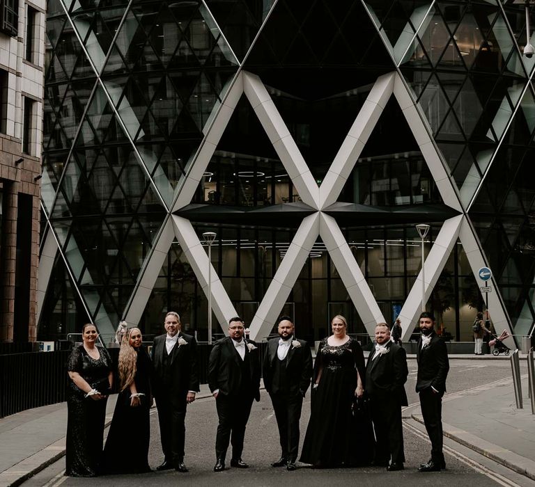 Wedding party in monochrome colour scheme standing outside The Gherkin wedding venue London 