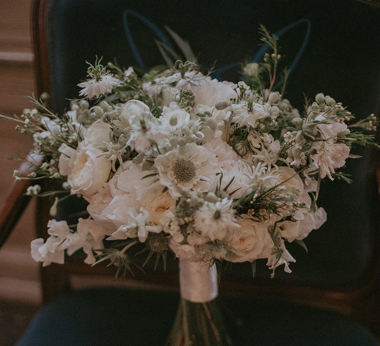 All white flower wedding bouquet for the bride tied up with shiny white ribbon 