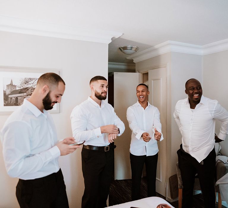 Groom and groomsmen get dressed for the wedding day at Colville Hall