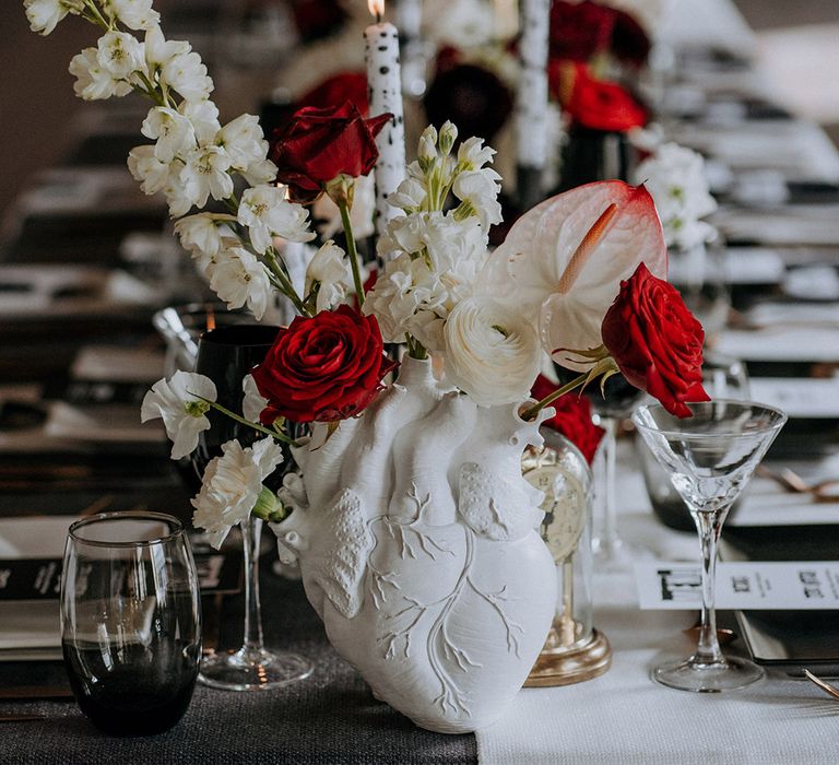 White heart anatomy vase holding red and black wedding flowers for monochrome gothic wedding 