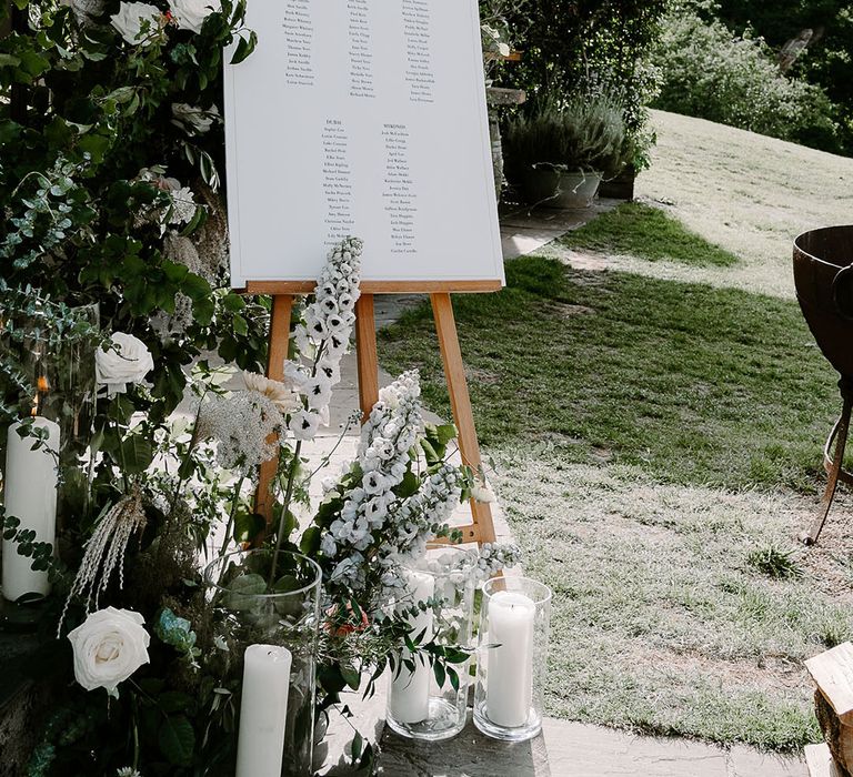 White wedding seating chart with white wedding flowers and decorations 