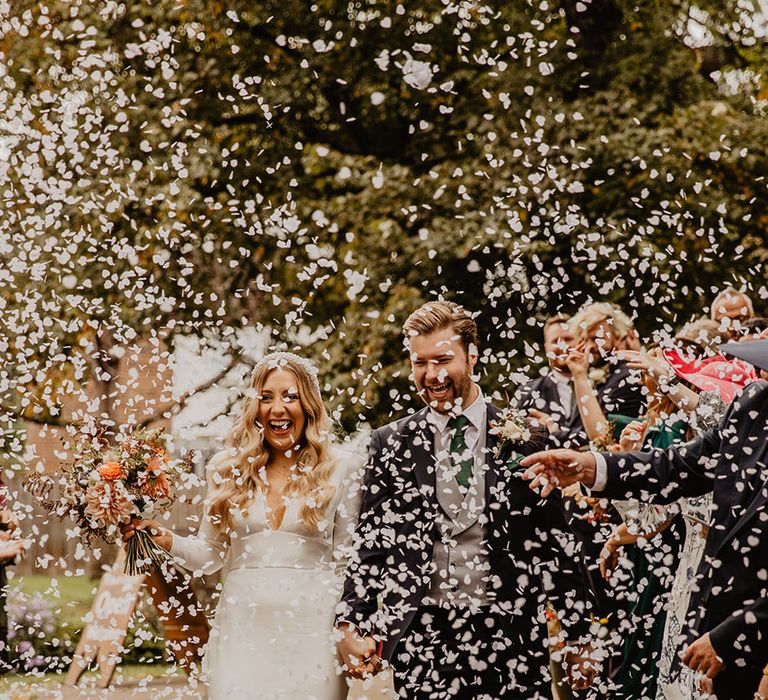 The bride and groom exit their church wedding ceremony to confetti 