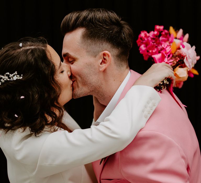 The bride and grooms share a kiss together 