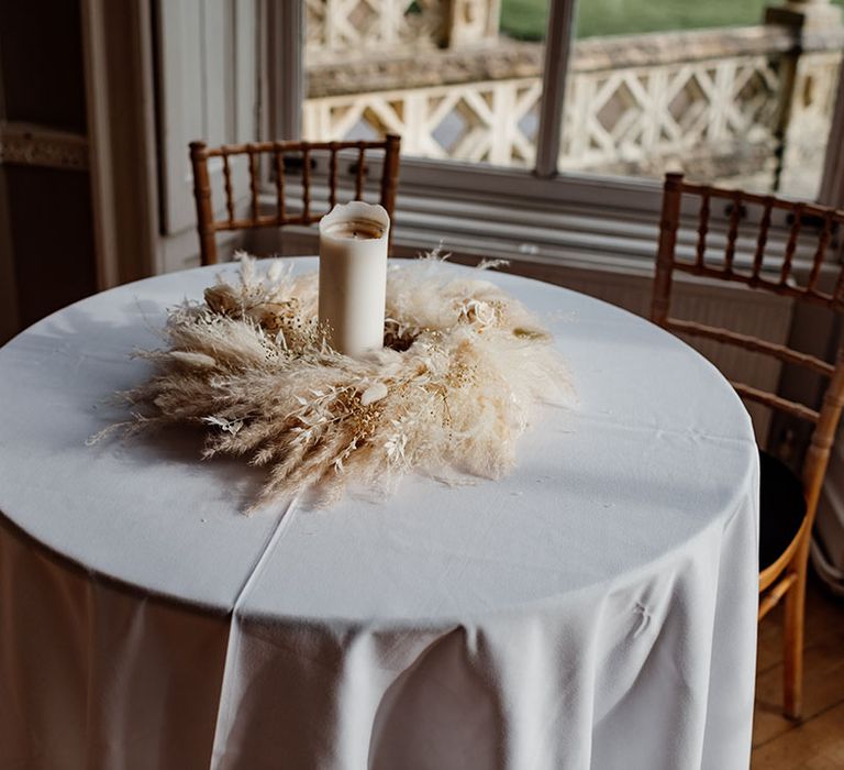 Pampas grass and white pillar candle table centrepiece for signing the register 