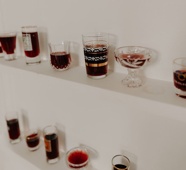 Shot glasses filled with alcohol on wedding signage for guests to toast to the married couple 