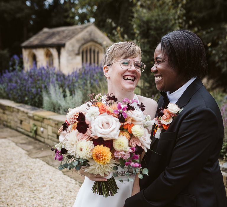 Stunning autumnal bouquet for October wedding held by bride in couple portrait 