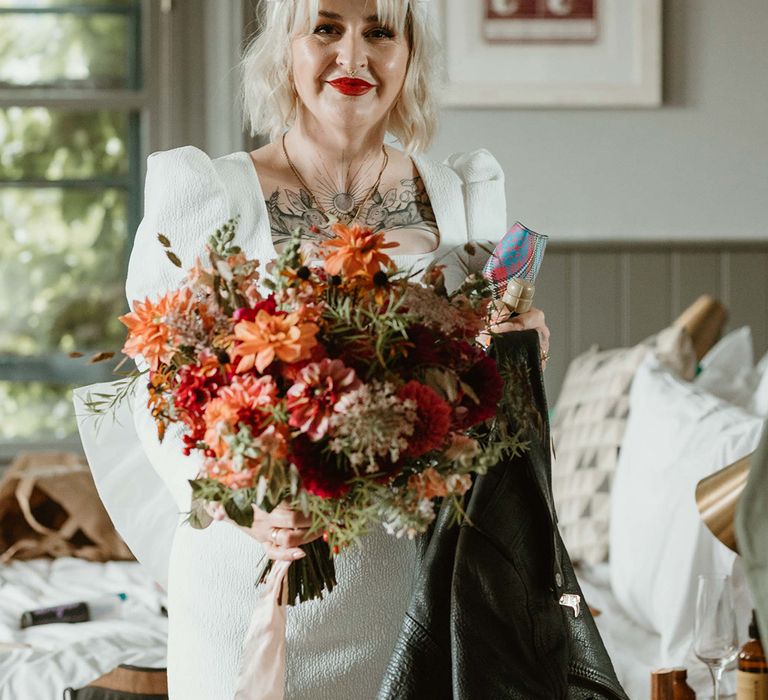 Bride in short wedding dress with square neckline wearing a white headband accessory with autumnal seasonal bouquet 