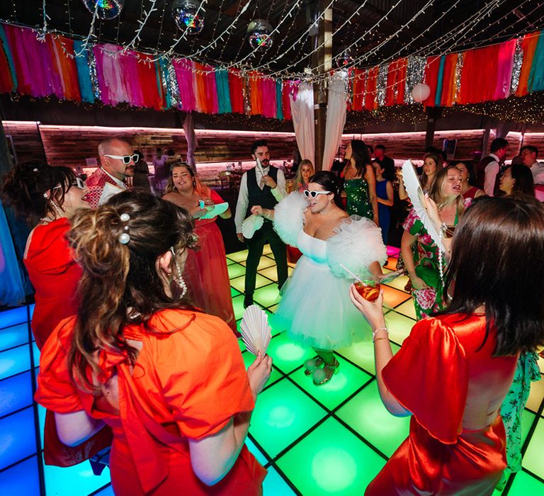 Light up dancefloor for wedding reception with guests dancing 